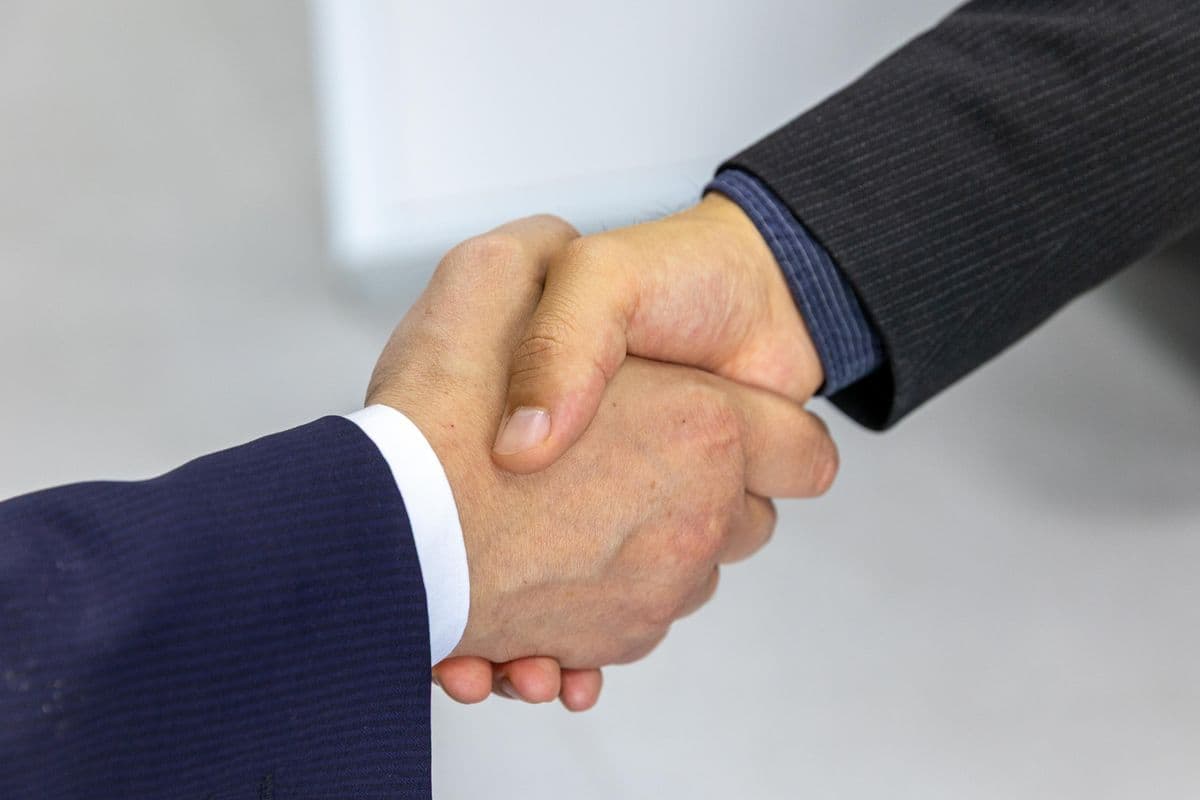 Two business professionals shaking hands to confirm an agreement